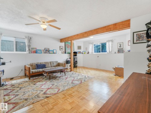 This spacious living area features parquet hardwood flooring, a ceiling fan, and large windows providing ample natural light - 308 Beringer Crescent, Edmonton, AB - Indoor
