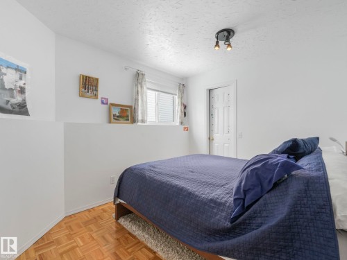 This room features parquet flooring, white walls, and a window with horizontal blinds - 308 Beringer Crescent, Edmonton, AB - Indoor Photo Showing Bedroom