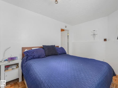 The bedroom features white walls, a white ceiling with a single light fixture, and a wooden headboard - 308 Beringer Crescent, Edmonton, AB - Indoor Photo Showing Bedroom