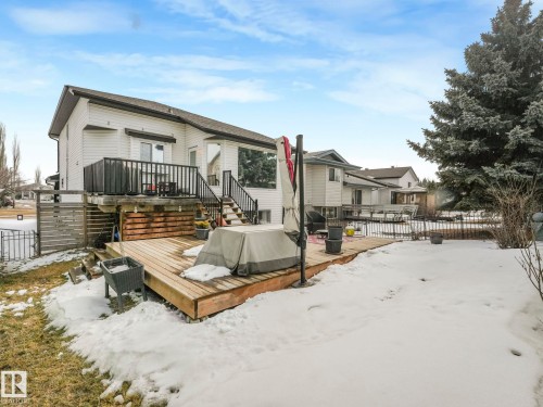 The property features a tiered outdoor living space with a wooden deck and an elevated balcony, complete with black railings - 308 Beringer Crescent, Edmonton, AB - Outdoor With Deck Patio Veranda