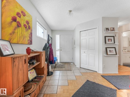 The entry area features tile flooring, a white front door, and a white bi-fold closet - 308 Beringer Crescent, Edmonton, AB - Indoor Photo Showing Other Room