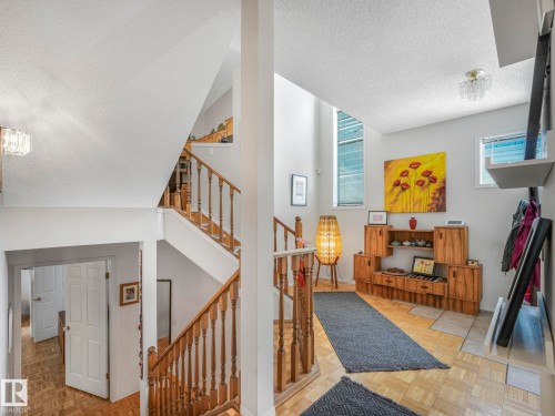 The property features a staircase with wooden railings and a light-colored wood floor - 308 Beringer Crescent, Edmonton, AB - Indoor Photo Showing Other Room