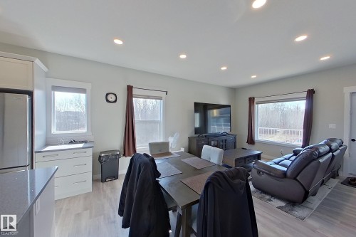 Open-concept living space featuring recessed lighting, light-toned wood-finish flooring, and multiple windows - 33 150 Everitt Dr, St. Albert, AB - Indoor