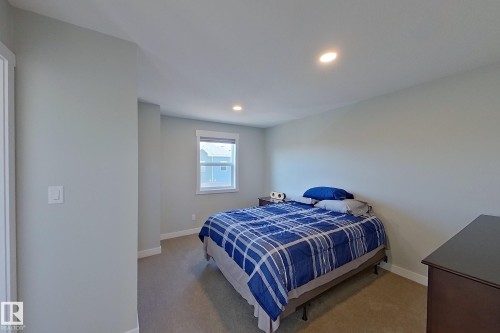 Carpeted room featuring light gray walls, recessed lighting, and a white-trimmed window - 33 150 Everitt Dr, St. Albert, AB - Indoor Photo Showing Bedroom