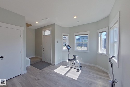 Entryway featuring wood-finish flooring, light grey wall paint, and white trim - 33 150 Everitt Dr, St. Albert, AB - Indoor Photo Showing Gym Room