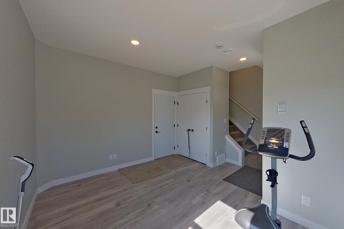 Spacious room with wood-finish flooring, light grey walls, white trim, and recessed lighting - 33 150 Everitt Dr, St. Albert, AB - Indoor Photo Showing Other Room
