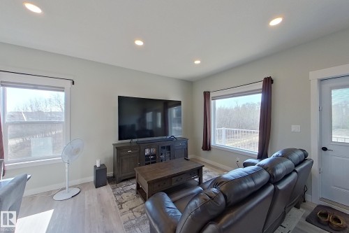 Open concept living area featuring light-toned walls and wood-finish flooring - 33 150 Everitt Dr, St. Albert, AB - Indoor Photo Showing Living Room