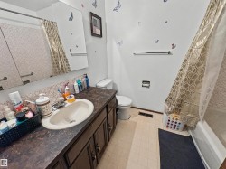 Bathroom featuring a vanity with an integrated sink, a built-in medicine cabinet, a toilet, and a shower-over-tub combination - 