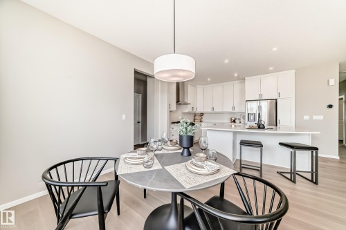 Dining area with light wood-finish flooring and a contemporary pendant light fixture - 1603 206 Street, Edmonton, AB - Indoor