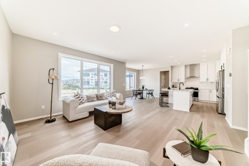 Open-concept living space featuring wood-finish flooring, recessed lighting, and large windows - 1603 206 Street, Edmonton, AB - Indoor Photo Showing Living Room