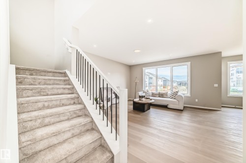 Carpeted staircase with white newel posts and black metal balusters - 1603 206 Street, Edmonton, AB - Indoor Photo Showing Other Room