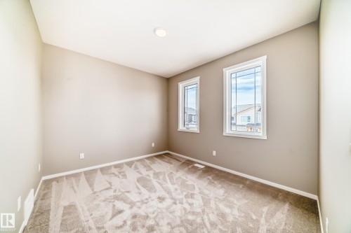 Neutral-toned walls complement the gray carpeting - 1603 206 Street, Edmonton, AB - Indoor Photo Showing Other Room
