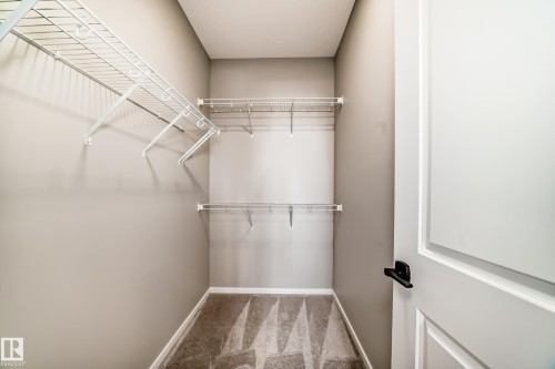 Walk-in closet featuring wire shelving, gray walls, and patterned carpet flooring - 1603 206 Street, Edmonton, AB - Indoor With Storage
