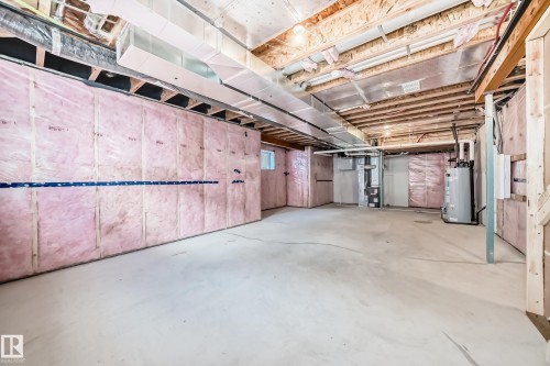 Unfinished basement featuring insulated walls, exposed ceiling joists, concrete flooring, and visible ductwork - 1603 206 Street, Edmonton, AB - Indoor Photo Showing Basement