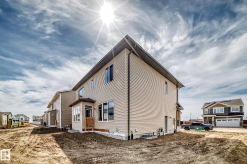 Newly constructed residence featuring beige siding and a dark shingled roof - 1603 206 Street, Edmonton, AB - Outdoor