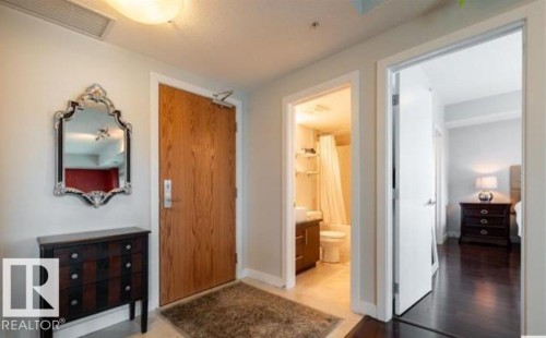 Entryway featuring a wood-finish door, light-colored flooring, and recessed lighting - 702 10055 118 Street, Edmonton, AB - Indoor Photo Showing Other Room
