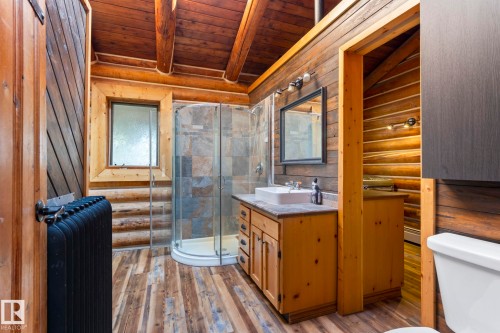 Rustic bathroom featuring a wood-finish flooring, log wall construction, and a wood plank ceiling - A & B, 4858 Centre St, New Sarepta, AB - Indoor Photo Showing Bathroom