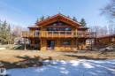 Log home featuring a second-story balcony, prominent gabled roofline, and a full-height window array - A & B, 4858 Centre St, New Sarepta, AB  - Outdoor With Deck Patio Veranda 