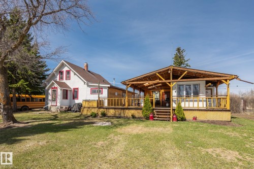 Exterior with white siding and red trim detailing - A & B, 4858 Centre St, New Sarepta, AB - Outdoor With Deck Patio Veranda