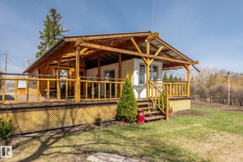 Expansive wooden deck featuring a covered pergola, natural wood railings, and lattice skirting - A & B, 4858 Centre St, New Sarepta, AB - Outdoor With Deck Patio Veranda