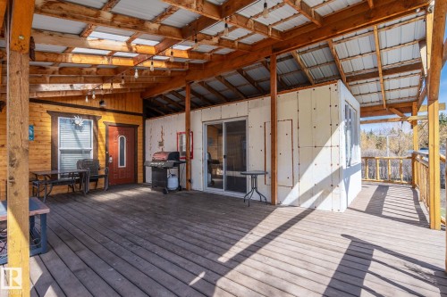 Expansive covered deck featuring wood-finish flooring and a metal roof - A & B, 4858 Centre St, New Sarepta, AB -  With Deck Patio Veranda With Exterior