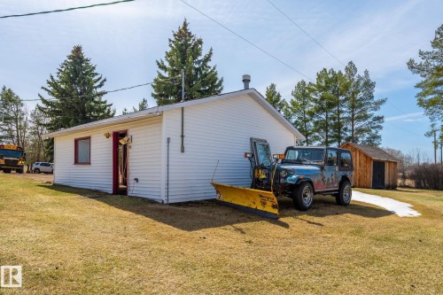 White-sided outbuilding with red trim and an exterior light fixture - A & B, 4858 Centre St, New Sarepta, AB - Outdoor With Exterior