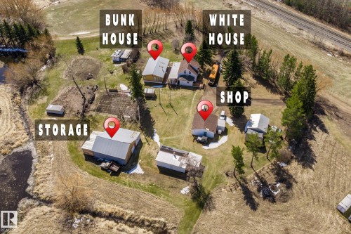 Aerial overview of a multi-structure property featuring a main residence, a secondary residence, a shop, and a large storage building - A & B, 4858 Centre St, New Sarepta, AB - Outdoor With View