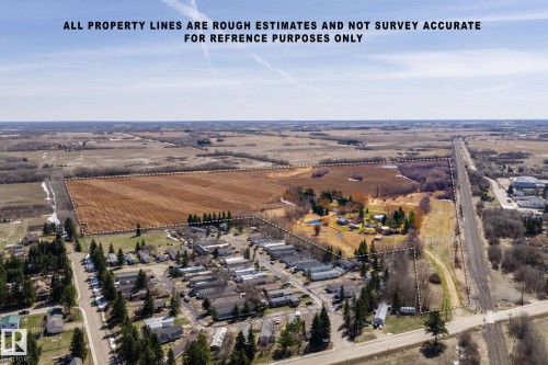 Expansive land parcel featuring cleared agricultural fields, wooded areas, and a residential-zoned section with multiple structures - A & B, 4858 Centre St, New Sarepta, AB - Outdoor With View