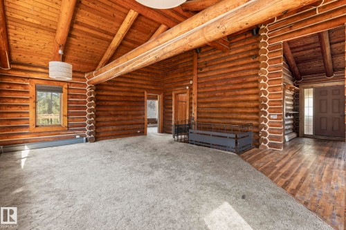 Expansive living area featuring log construction walls and exposed log beams - A & B, 4858 Centre St, New Sarepta, AB - Indoor Photo Showing Other Room
