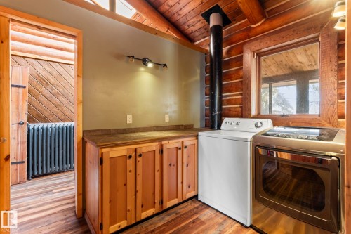 Utility area featuring wood-finish flooring and a wood ceiling with exposed beams - A & B, 4858 Centre St, New Sarepta, AB - Indoor Photo Showing Laundry Room