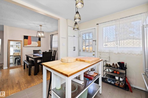 Kitchen island with a light wood butcher block countertop - 11607 141 Street, Edmonton, AB - Indoor Photo Showing Dining Room
