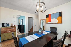 Open-concept dining area featuring wood-finish flooring, a contemporary ceiling light fixture, and arched doorways - 