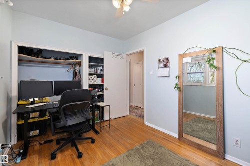 Room featuring wood-finish flooring, light blue walls, and a ceiling fan with integrated lighting - 11607 141 Street, Edmonton, AB - Indoor Photo Showing Office