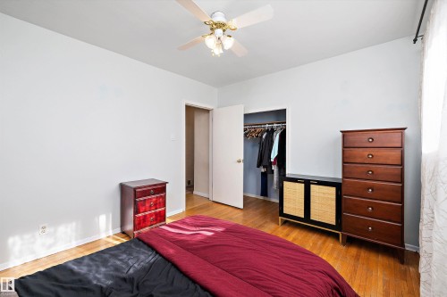 Bedroom featuring wood-finish flooring, a ceiling fan with integrated lighting, and a closet with an open doorway - 11607 141 Street, Edmonton, AB - Indoor Photo Showing Bedroom