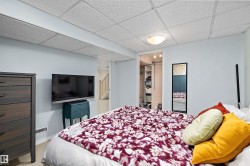 Bedroom featuring light blue walls, a drop ceiling, and carpet flooring - 