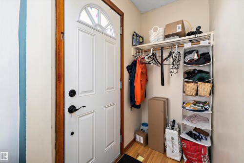 Entryway featuring a white paneled door with an arched top window, dark hardware, and natural wood trim - 11607 141 Street, Edmonton, AB - Indoor Photo Showing Other Room