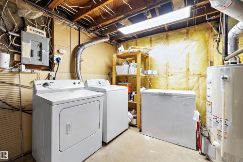 Utility area featuring a top-load washing machine, front-load dryer, chest freezer, and water heater - 11607 141 Street, Edmonton, AB - Indoor Photo Showing Laundry Room