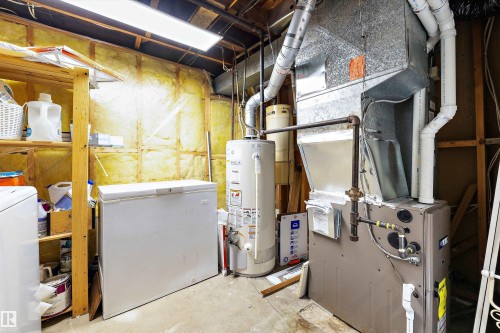Utility room featuring exposed insulation, a water heater, and a furnace unit - 11607 141 Street, Edmonton, AB - Indoor Photo Showing Basement