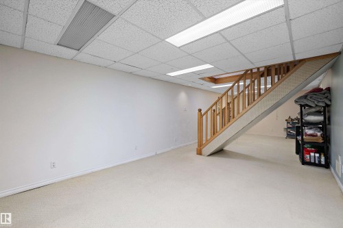 Finished lower level featuring a light wood staircase, light-colored carpeting, a drop ceiling with recessed lighting, and ample wall space - 11607 141 Street, Edmonton, AB - Indoor