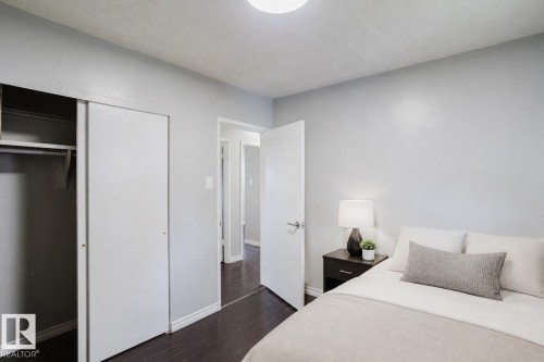 Bedroom with dark wood-finish flooring, light grey walls, and white trim - 10325 152 Street, Edmonton, AB - Indoor Photo Showing Bedroom