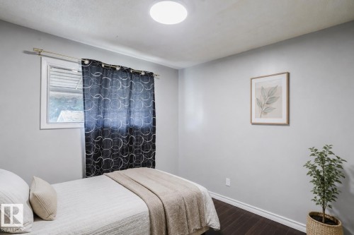 Interior space featuring a single window with white trim, dark wood-finish flooring, and light gray wall paint - 10325 152 Street, Edmonton, AB - Indoor Photo Showing Bedroom