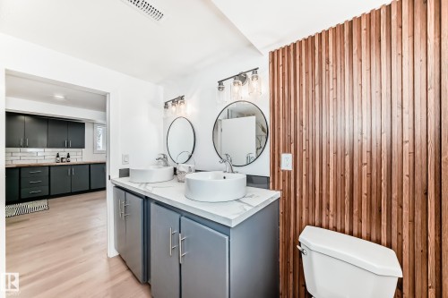 Contemporary bathroom featuring a unique vertical wood slat accent wall - 8712 89 Avenue, Edmonton, AB 
