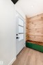 Entryway featuring a white paneled door with frosted glass inserts, matte black hardware, and wood-finish flooring - 8712 89 Avenue, Edmonton, AB 
