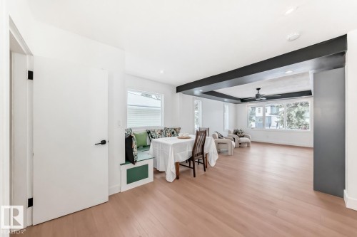 Open-concept living area featuring wood-finish flooring, recessed lighting, and a built-in window bench - 8712 89 Avenue, Edmonton, AB 