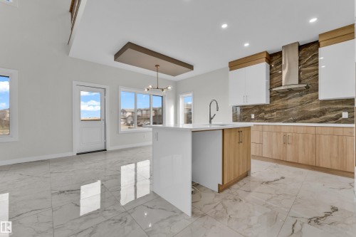 Contemporary kitchen featuring a central island with an integrated sink and gooseneck faucet - 12603 44 Street, Edmonton, AB - Indoor Photo Showing Kitchen