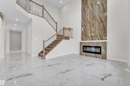 Grand entry space featuring expansive white tile flooring with grey veining - 12603 44 Street, Edmonton, AB - Indoor With Fireplace