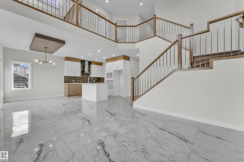 Open-concept living space featuring high ceilings, large format marble-look tile flooring, and a contemporary kitchen with a central island - 12603 44 Street, Edmonton, AB - Indoor Photo Showing Other Room