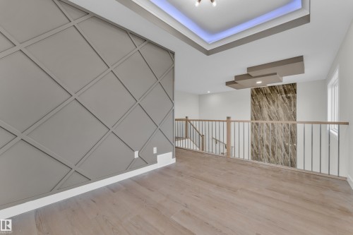 Contemporary wall paneling with a geometric design and light wood-finish flooring - 12603 44 Street, Edmonton, AB - Indoor Photo Showing Other Room