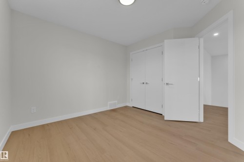 Room featuring wood-finish flooring, light gray walls, white baseboards, and a flush-mounted ceiling light - 12603 44 Street, Edmonton, AB - Indoor Photo Showing Other Room