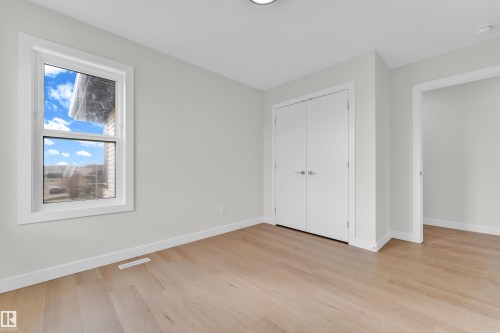 Bright room featuring light wood-finish flooring, a white trim window, and neutral wall tones - 12603 44 Street, Edmonton, AB - Indoor Photo Showing Other Room